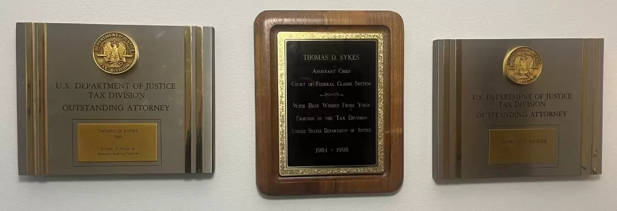 Three U.S. Department of Justice, Tax Division Outstanding Attorney award plaques presented to Thomas D. Sykes